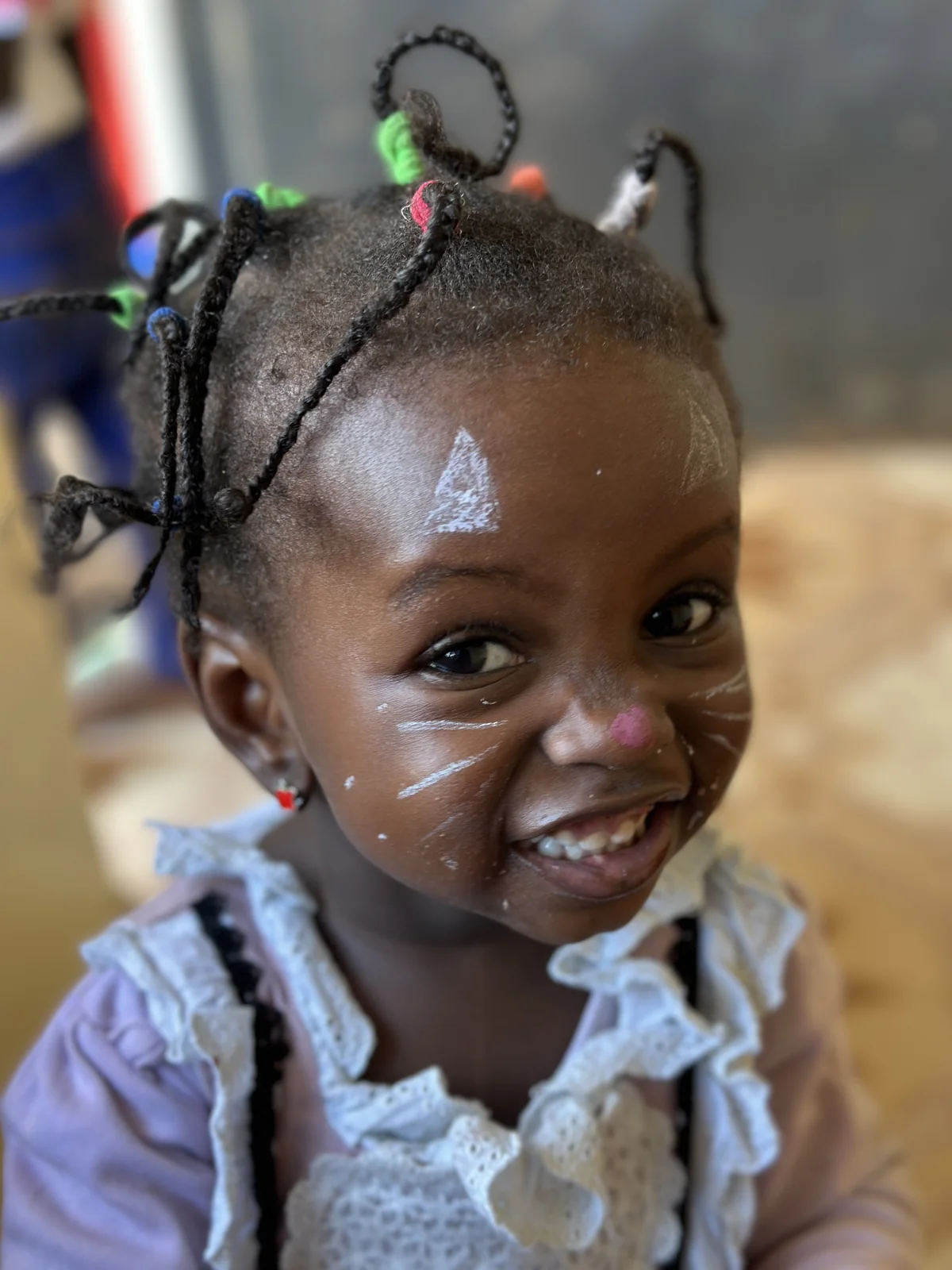 A smiling child with face paint