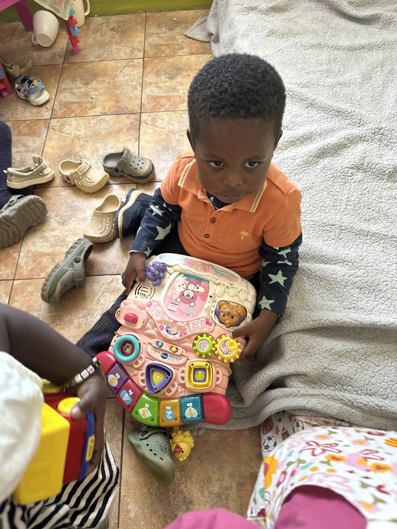 A child exploring a colourful activity board during playtime